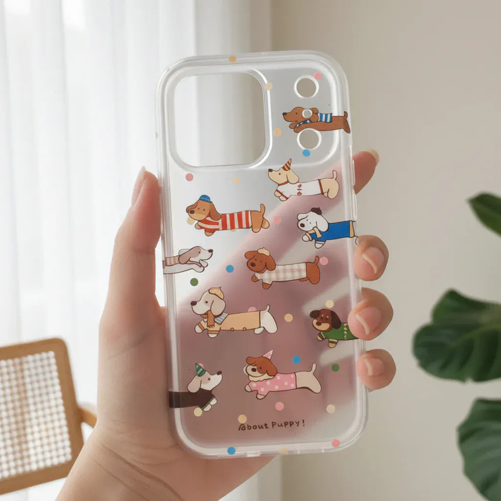 Phone case with cartoon dog designs held by a hand outdoors