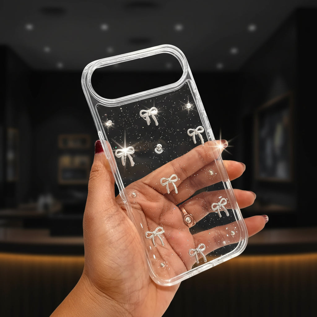 Clear phone case with bow designs held by a hand in a store setting