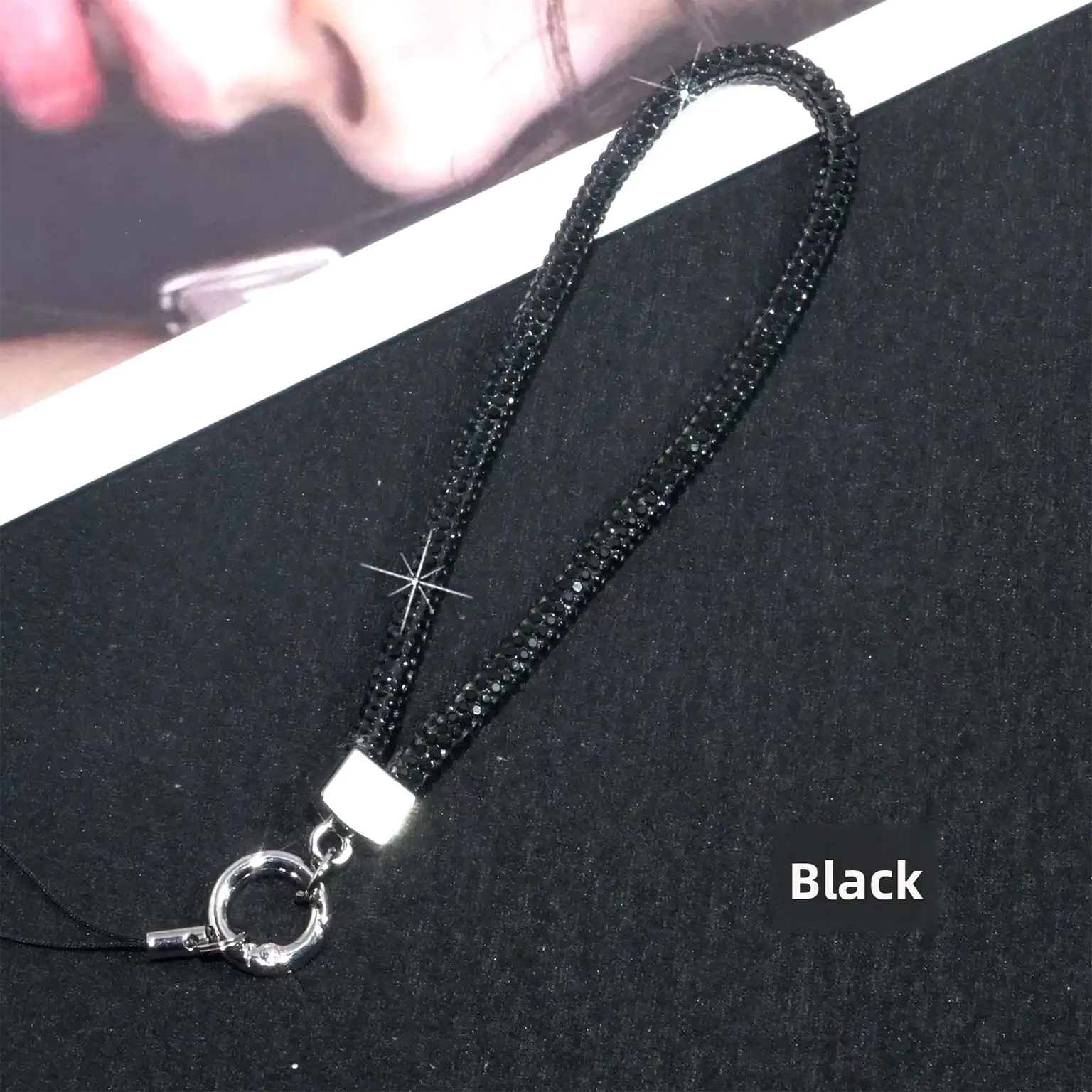 Black lanyard with a silver clasp on a black background