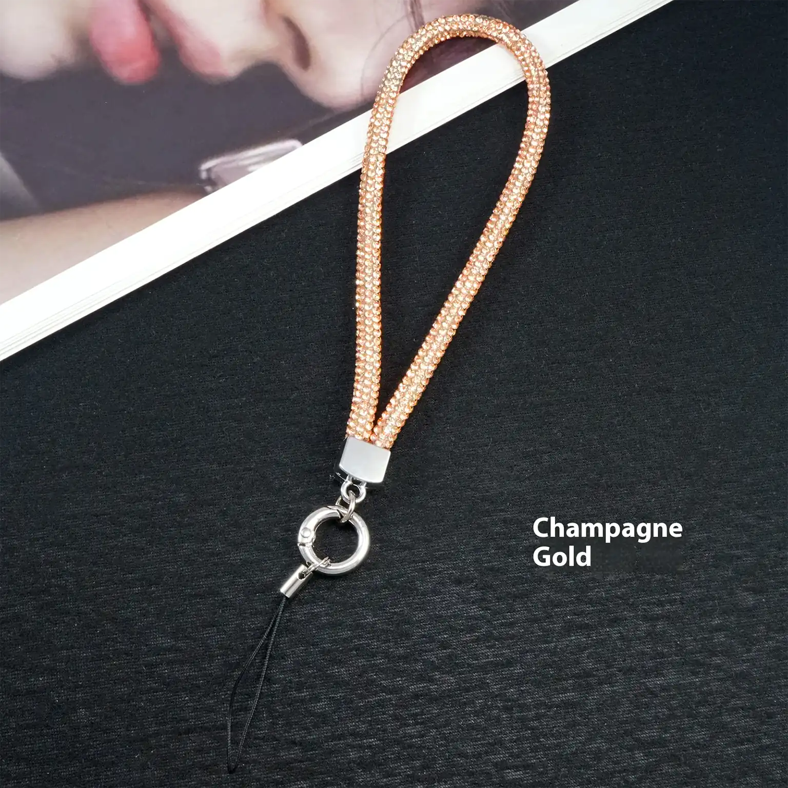 Champagne gold lanyard with a clip on a black background