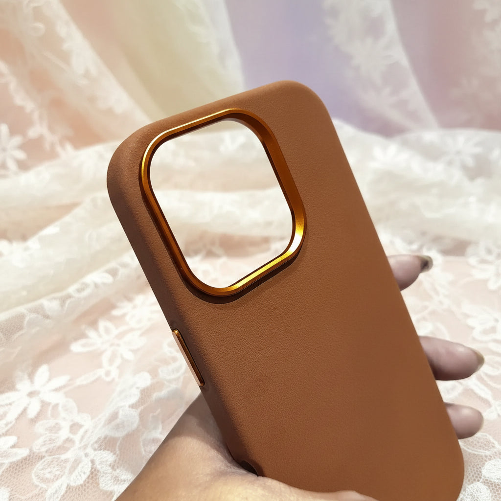 Brown phone case with gold accents held in a hand, blurred background