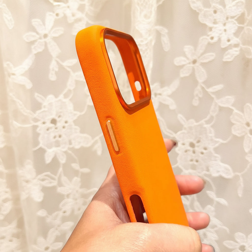 Orange phone case held in a hand with a blurred indoor background