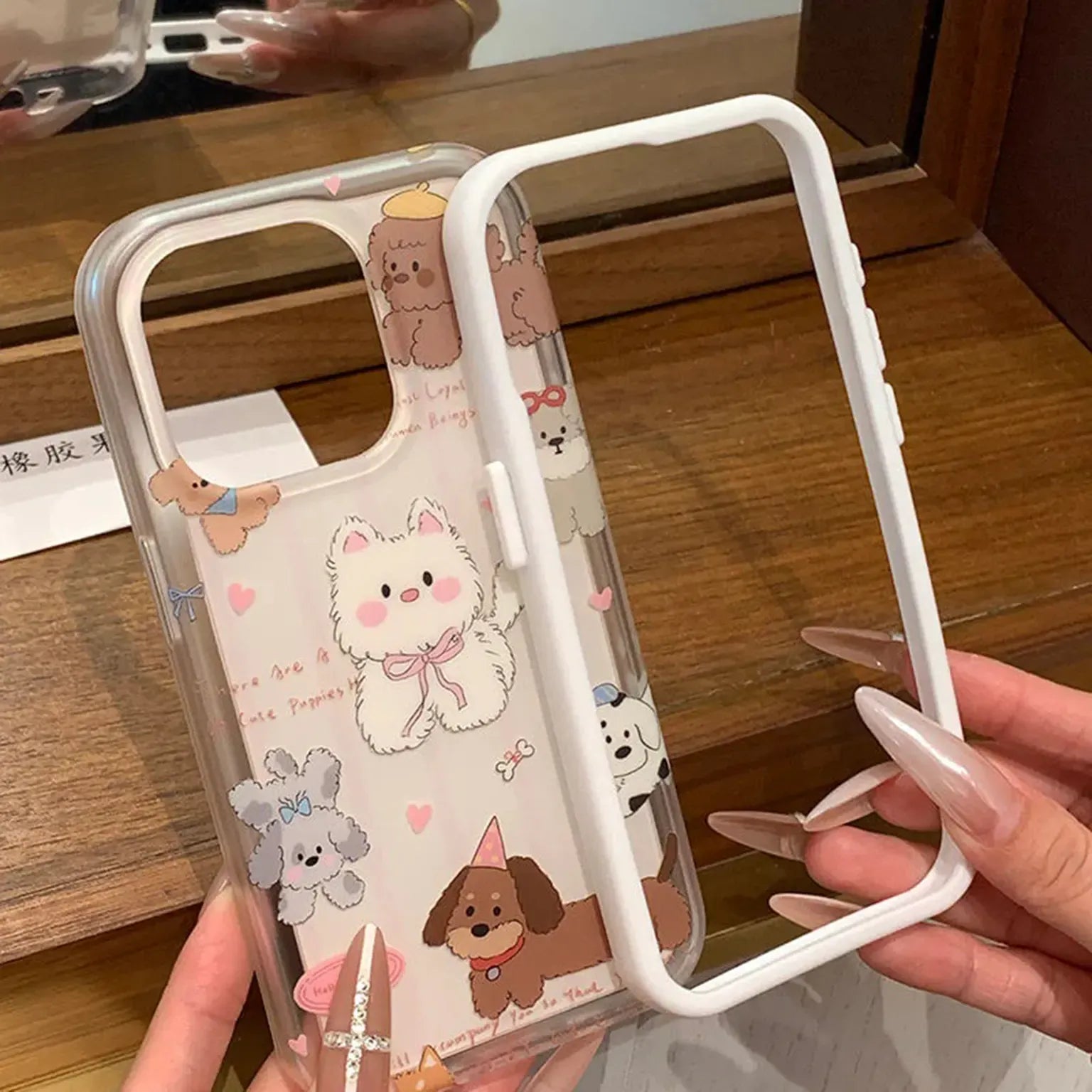 Phone case with cute animal designs held by a person on a wooden surface
