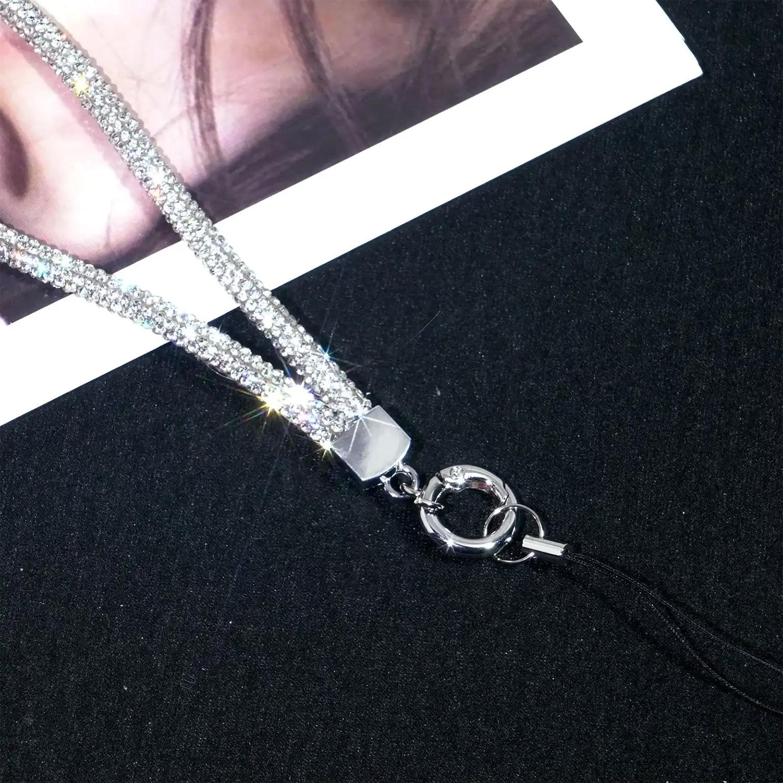 Silver lanyard with rhinestone details on a black background