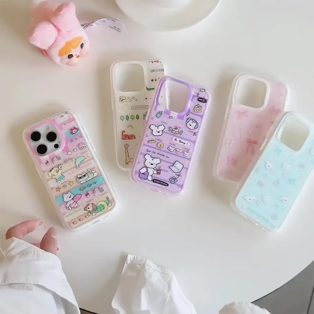 Set of colorful phone cases with cartoon designs on a white surface.