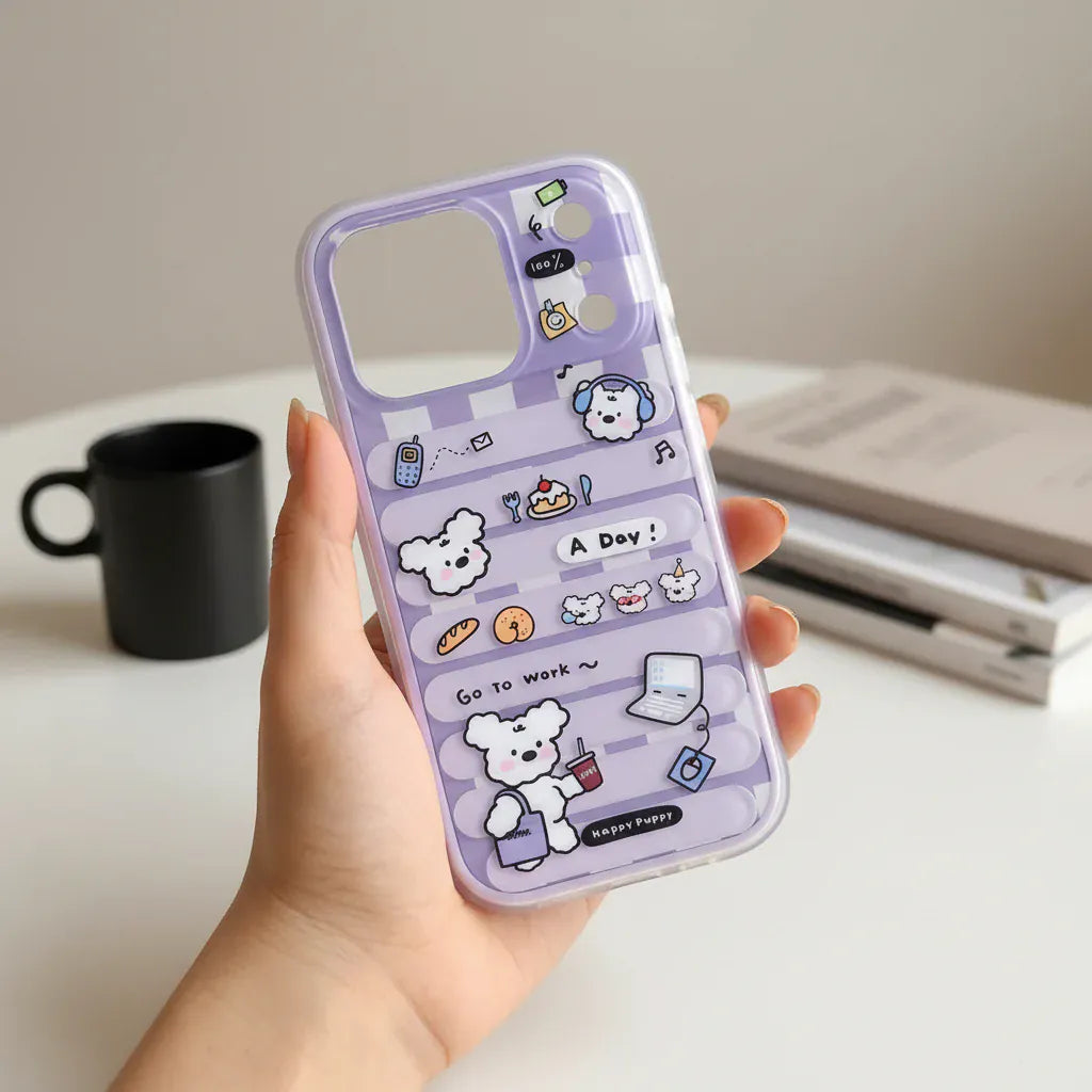 Phone case with cartoon designs held by a hand outdoors