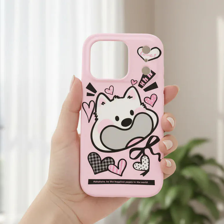 Pink phone case with cartoon design held by a hand, outdoor background