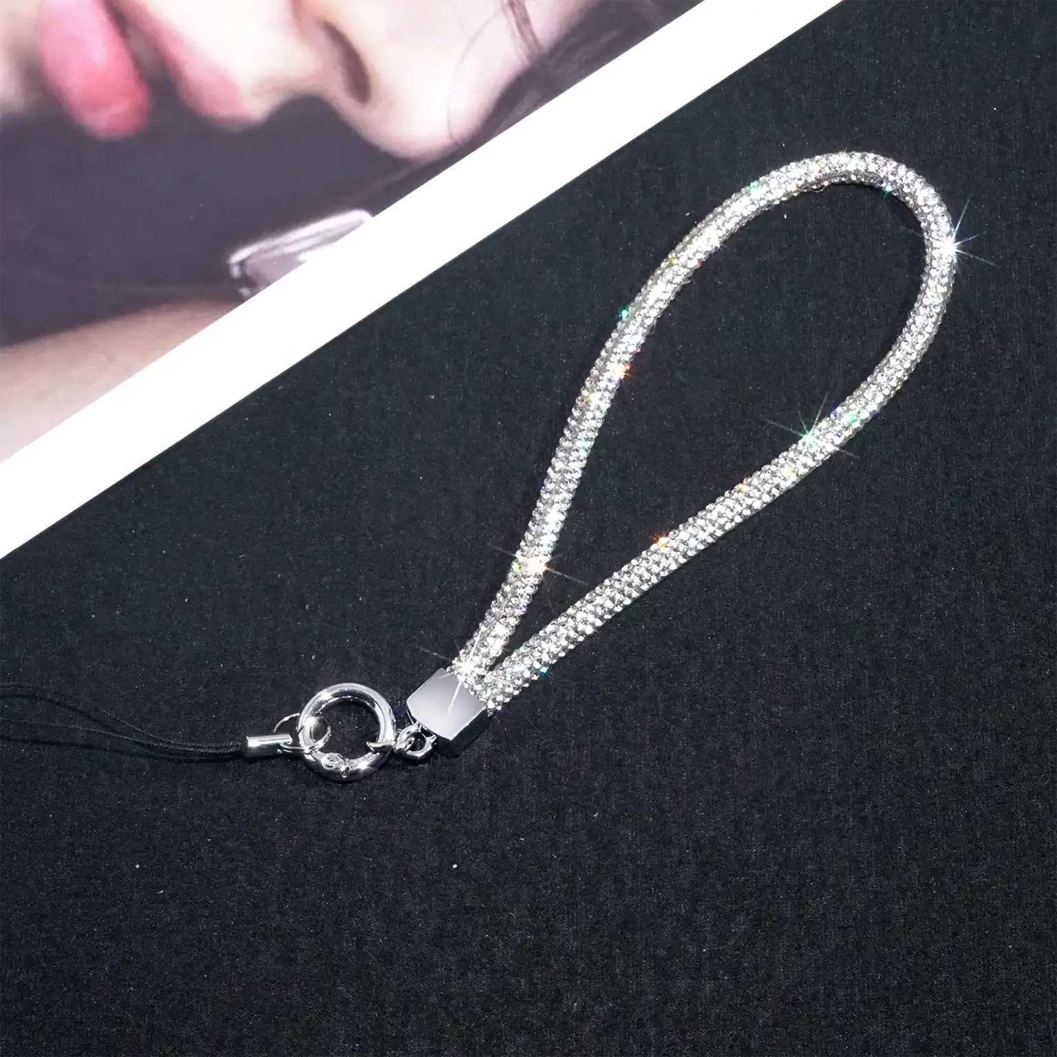 Silver phone strap on a black surface