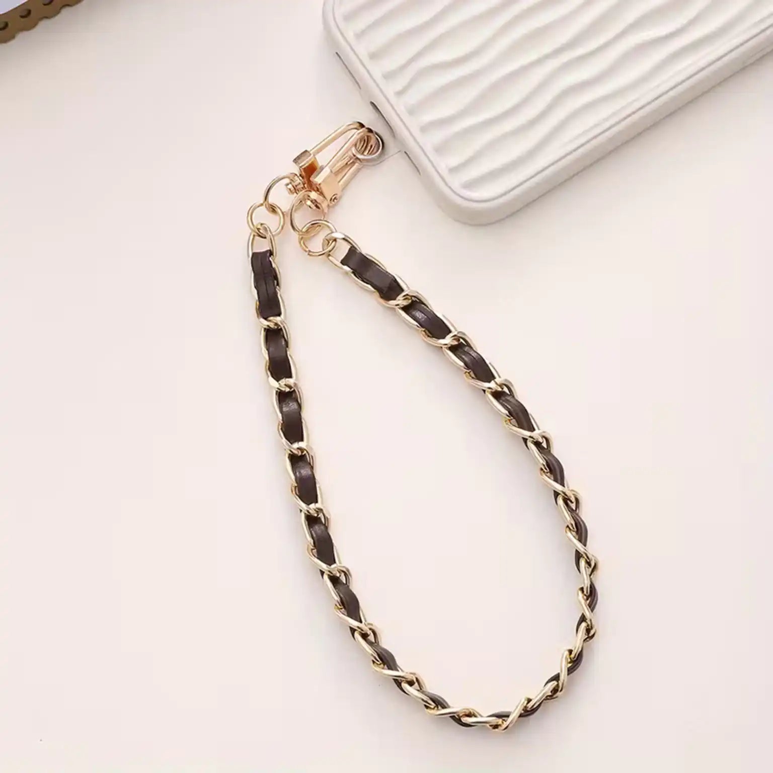Gold chain with braided design on a white background